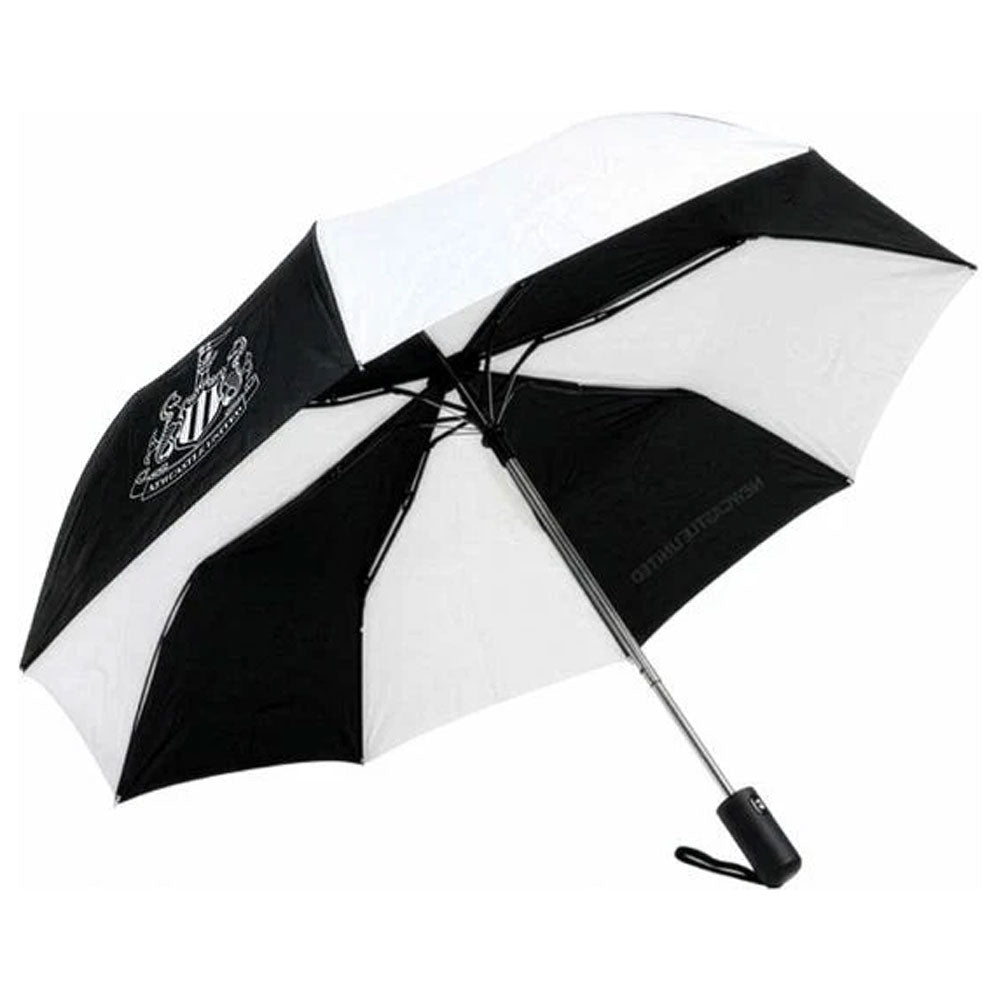 A black and white striped umbrella with a white and black Newcastle United crest printed on the black section, shown open against a plain white background.
