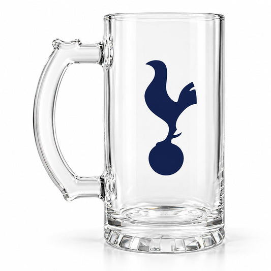 A clear glass beer mug with a thick handle and a navy blue Tottenham Hotspur logo printed on the front, set against a plain white background.